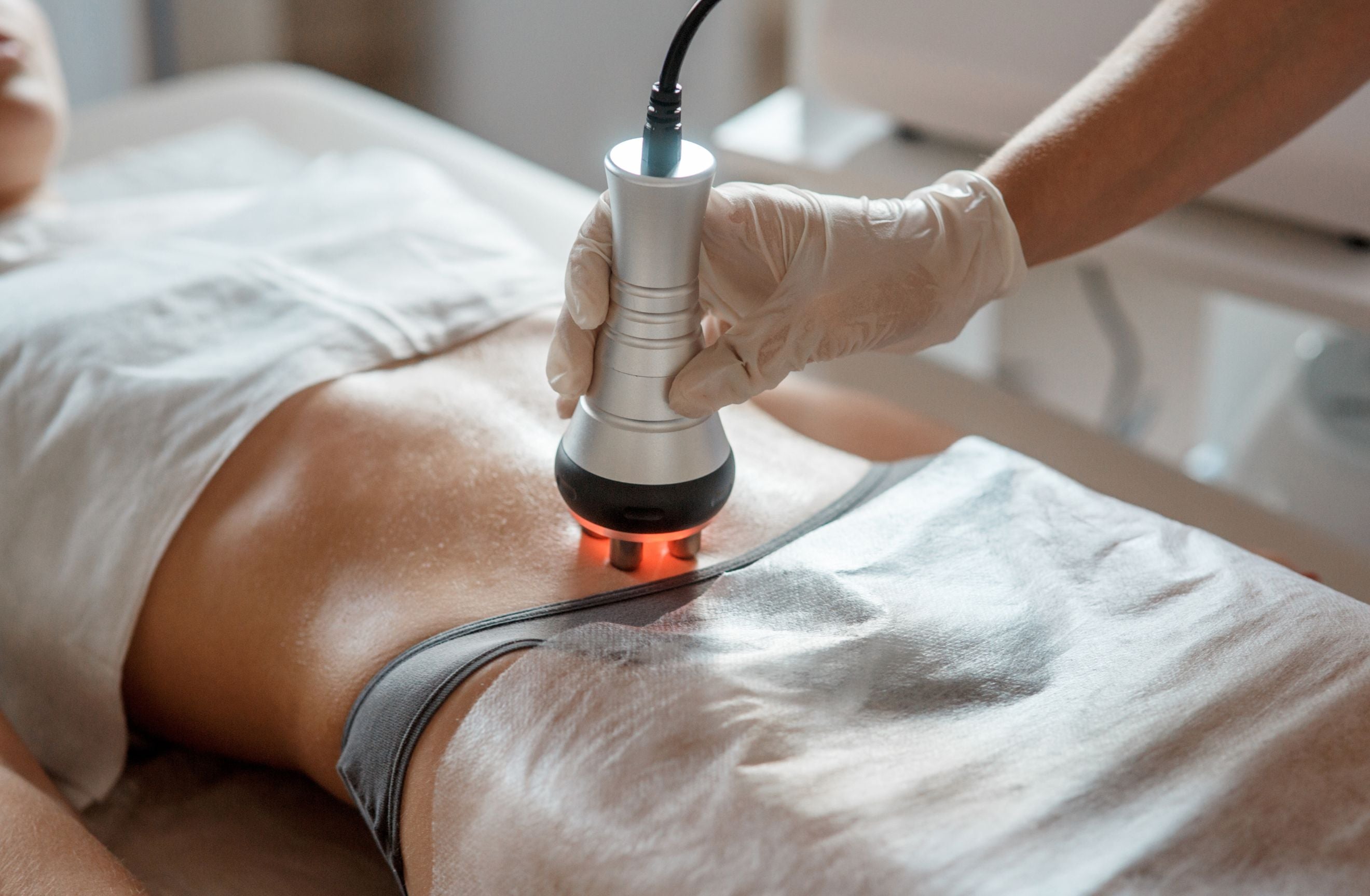 Woman on bed getting red light therapy