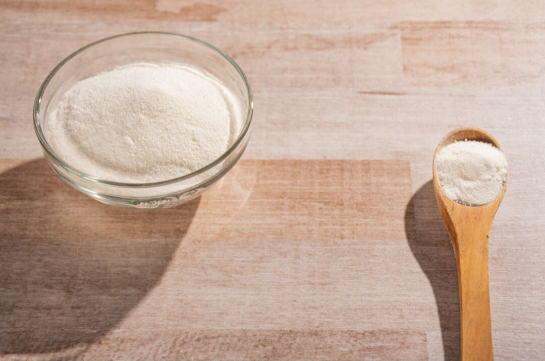 Protein powder in spoon and bowl